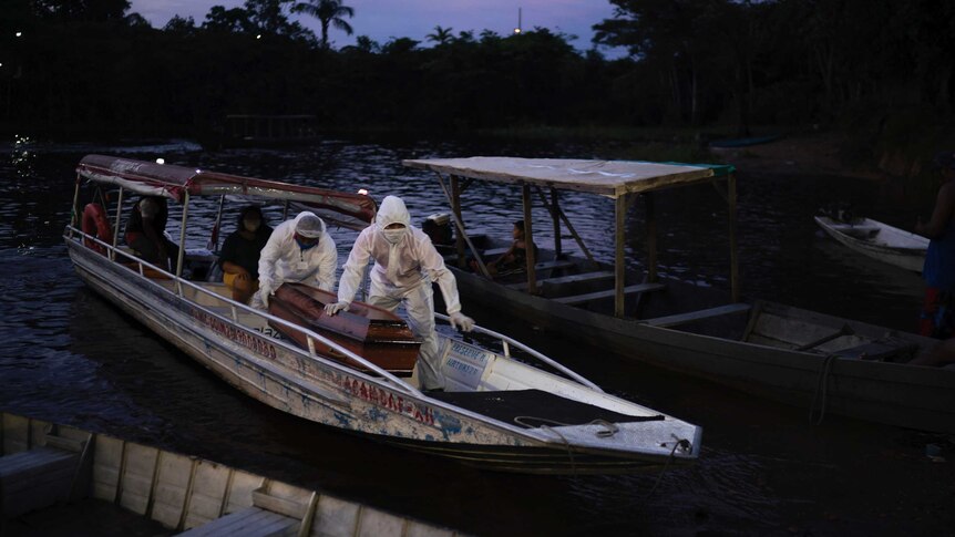 Funeral workers transport a body via boat in Brazil's Amazon.