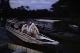 Funeral workers transport a body via boat in Brazil's Amazon.