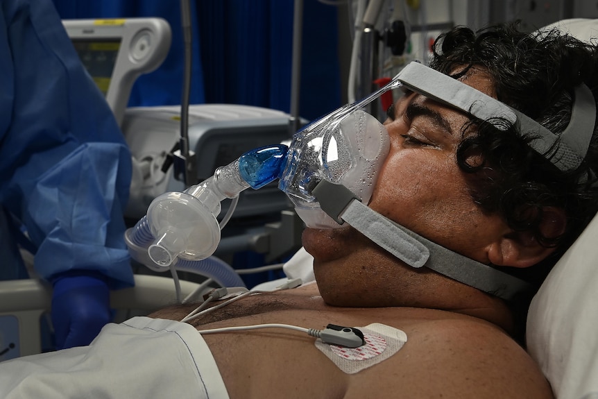 A man's face, covered with an oxygen mask.