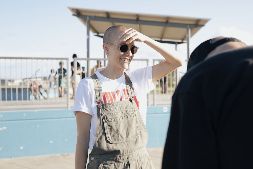 bald woman with sunglasses smiling