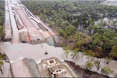 A birds-eye view showing trees and a railway partially inundated by water.