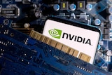 A close-up of a smartphone displaying an Nvidia logo, sandwiched between two computer parts. 