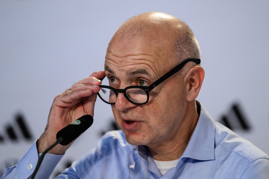 A bald man looks over his spectacles