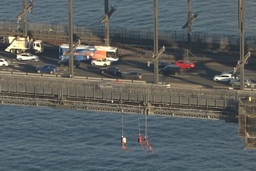 The protesters dangling off the bridge