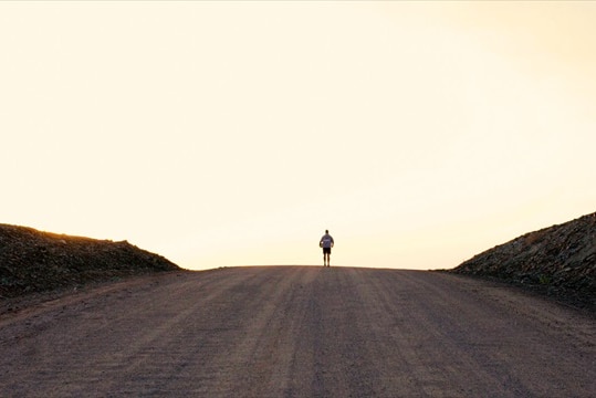 Matt Napier standing in the middle of the road in the African desert.