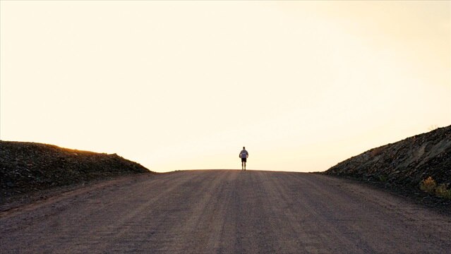 Matt Napier standing in the middle of the road in the African desert.