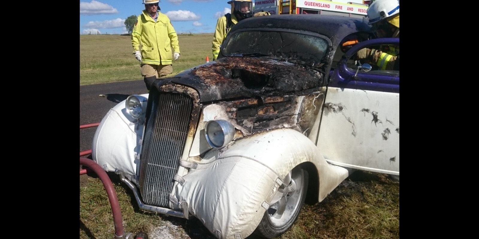 A car burnt out with emergency services.