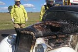 A car burnt out with emergency services.