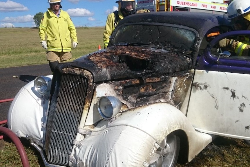 A car burnt out with emergency services.