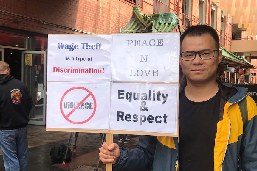 Jackie Chen from the SA Labour Info Hub holds a placard.