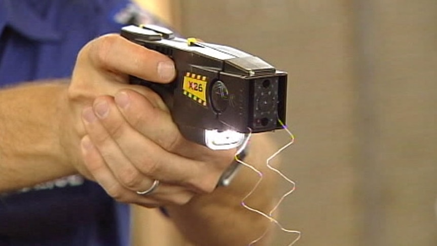 Close-up of police officer firing taser