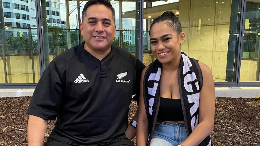 A man and his daughter, both wearing black and white