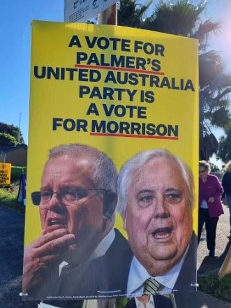 A yellow poster depicting two politicians side by side and suggesting a vote for the UAP is a vote for the prime minister