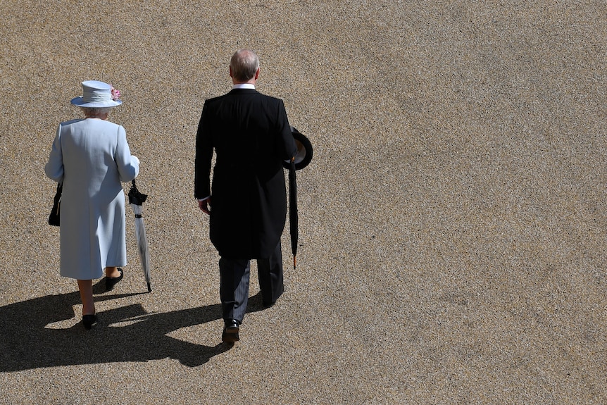The Queen and Prince Andrew, shot from above, walking across an empty quadrangle