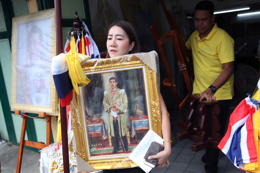 A Thai woman buys portrait of Thailand's King Maha Vajiralongkorn.