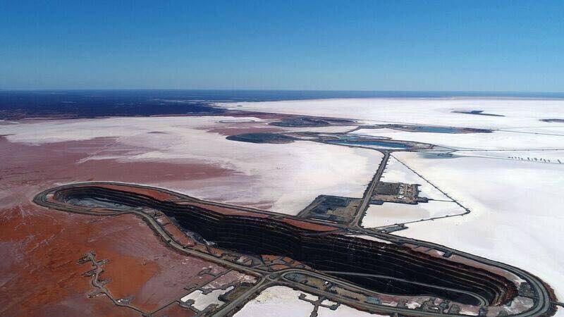 An aerial view of an open pit gold mine on a salt lake.