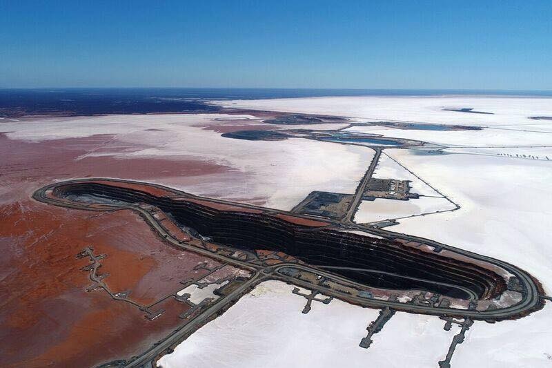 An aerial view of an open pit gold mine on a salt lake.