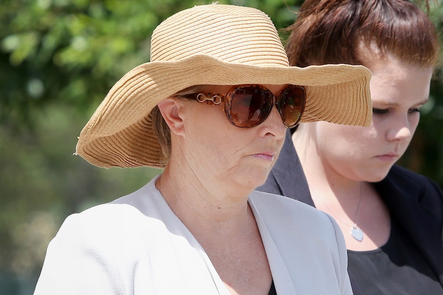 Julene Thorburn arrives at Beenleigh court wearing a straw hat and large sunglasses.