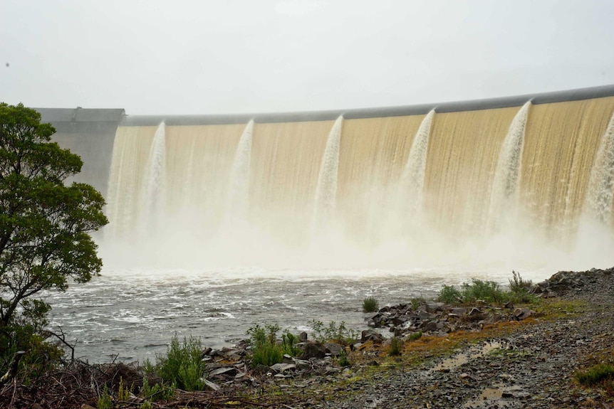 Water flows over the wall of the dam powering the Repulse Power Station.