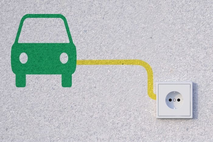 A simple green painting of a car leading to a power outlet