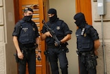 Police officers stand outside a building in Ripoll north of Barcelona where a suspect was taken into custody.