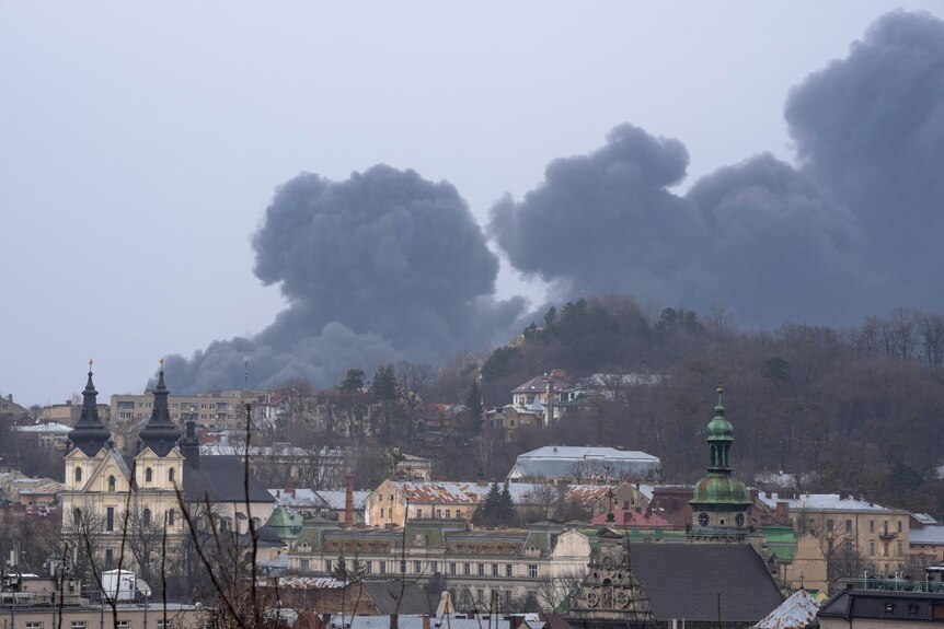Smoke rises in the air in Lviv cityscape.