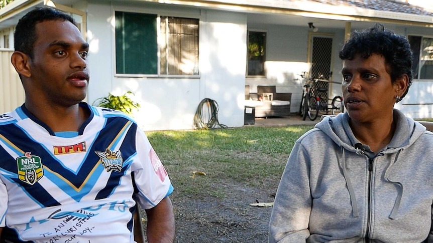 Indigenous player Anno Pitt sits with his mother Pauline Moore outside their house in the yard