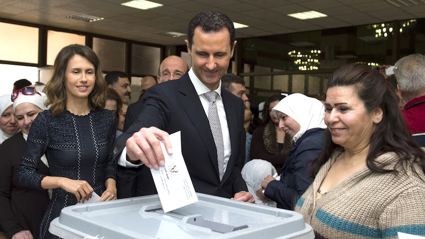 Syrian President Bashar al-Assad and his wife Asma casting their votes at a polling station