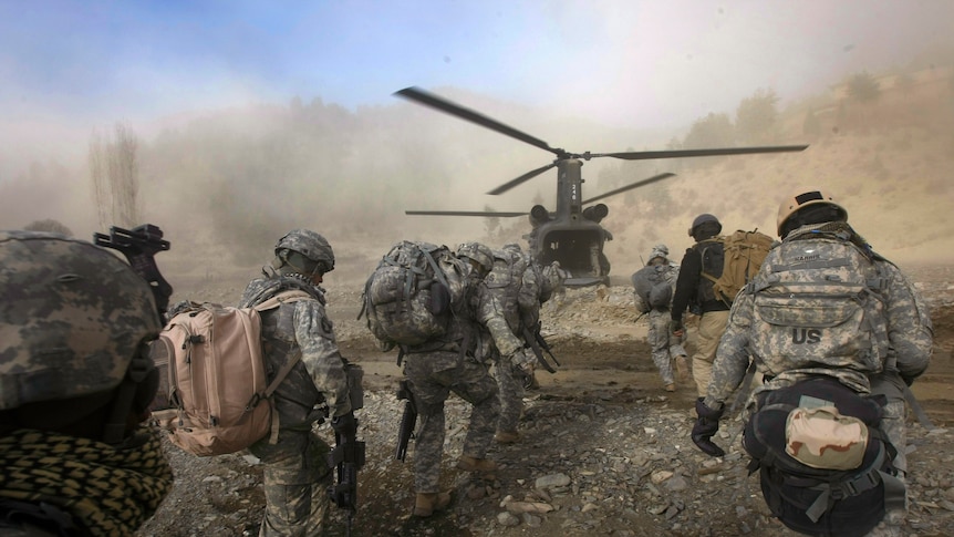 US soldiers move towards a Chinook helicopter