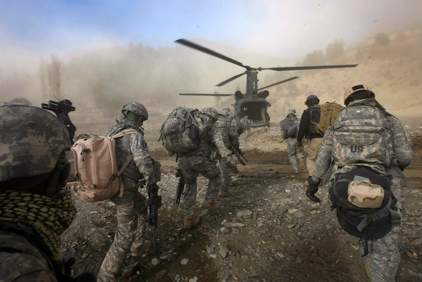 US soldiers move towards a Chinook helicopter