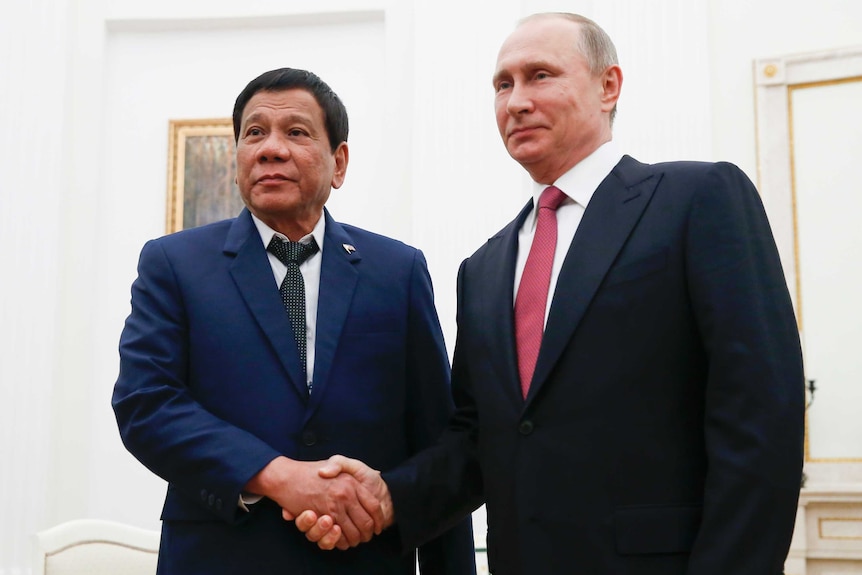 Philippines President Rodrigo Duterte and Russian President Vladimir Putin shake hands