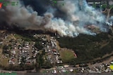 aerial view of a fire burning towards a township