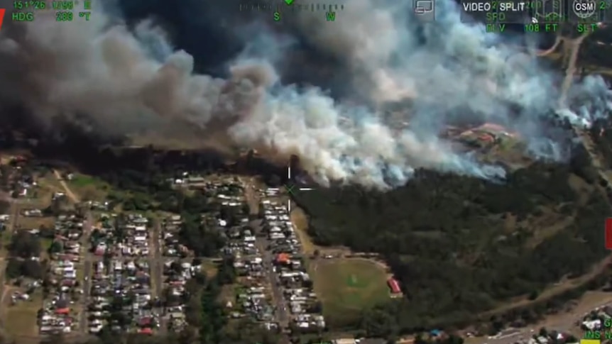 aerial view of a fire burning towards a township