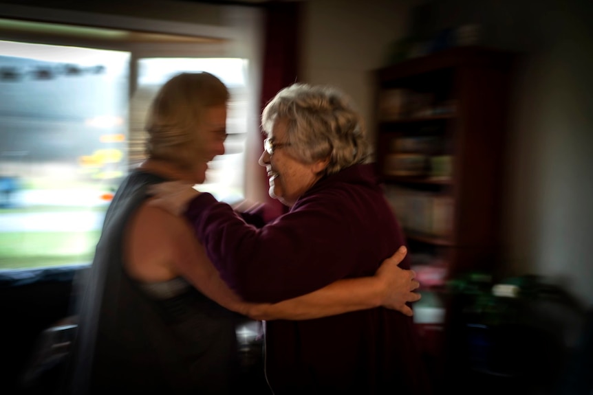 Susan Ryder supports her mother, Better Bednarowski, as they gently dance their way toward the bathroom.