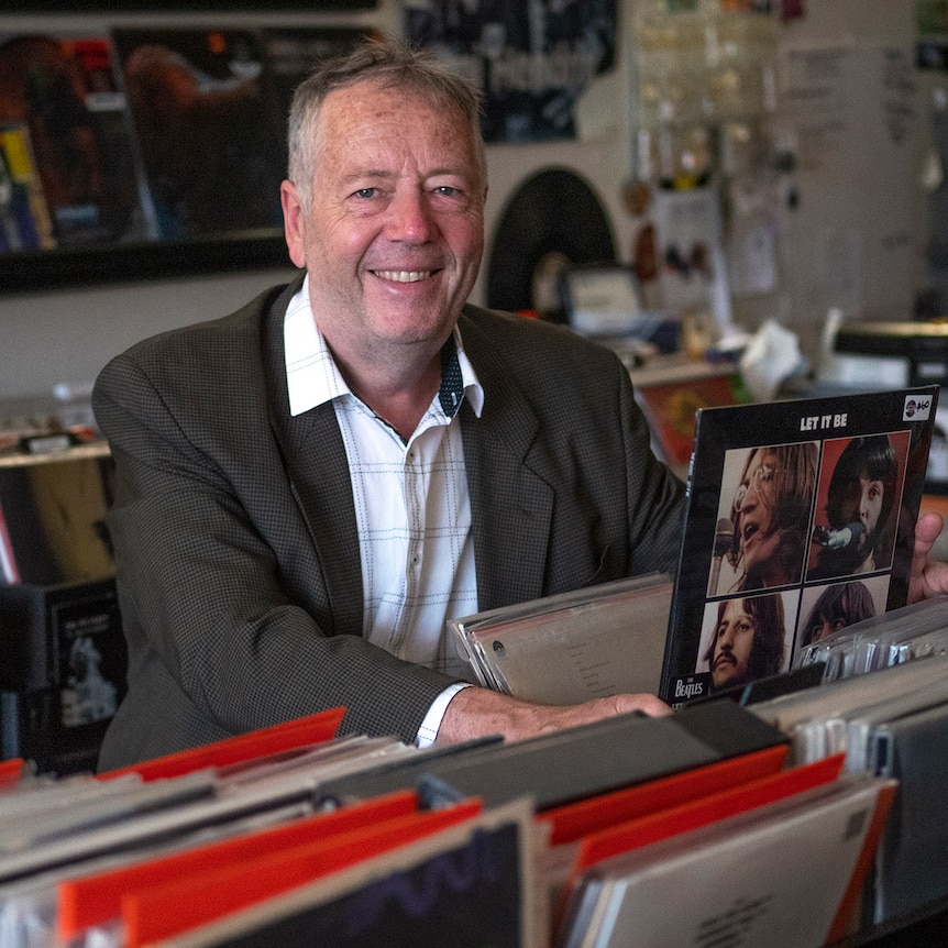 Paul Turton flipping through a stack of records in a music store.