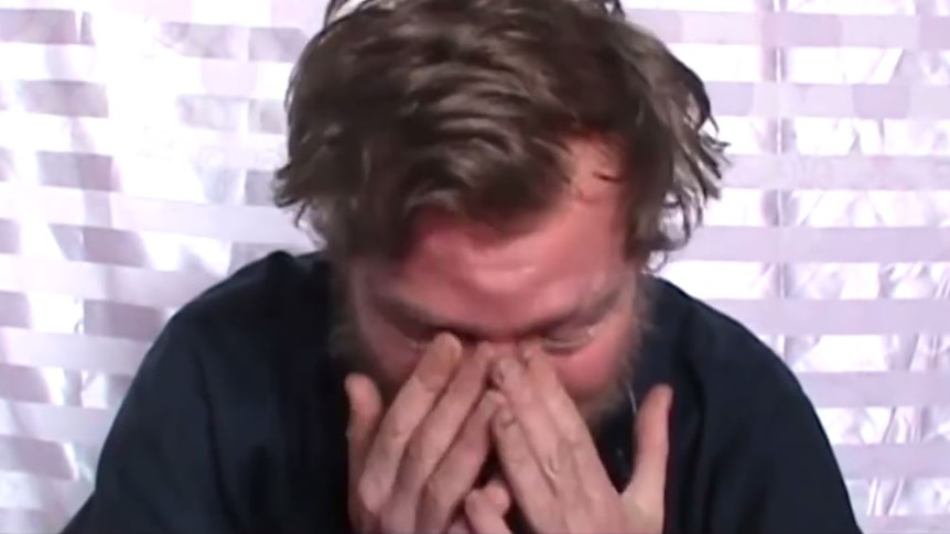 A man crying with his hands over his face