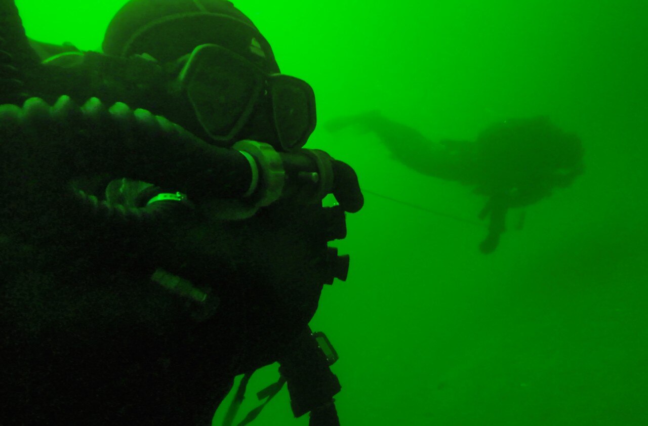 An image taken underwarer, showing two divers.