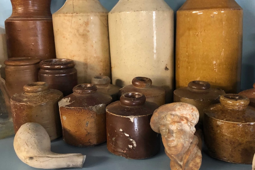 A collection of old school inkwells and bottles, sitting on a table.