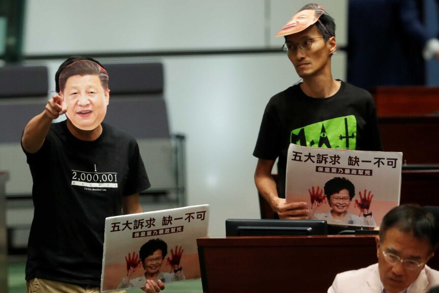 Hong Kong MPs wear masks of Chinese President Xi Jinping in parliament.