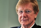 Kerry O'Brien posing for the camera in a suit.