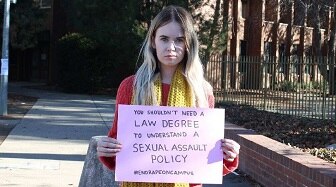 A student holds a sign campaigning for action on campus sexual assault.
