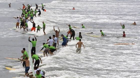 Brazilian surfers ride a wave as part of the world record attempt.