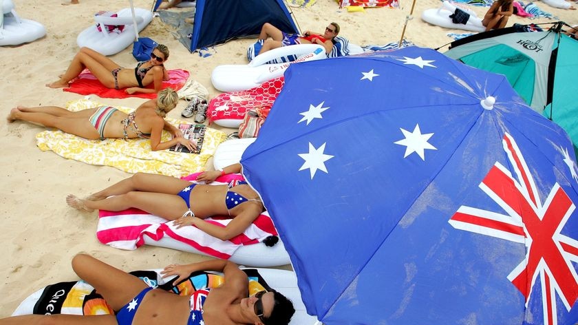 Beachgoers relax under an Australian flag beach umbrella on Australia Day at Bondi Beach, Sydney, January 26, 2011.
