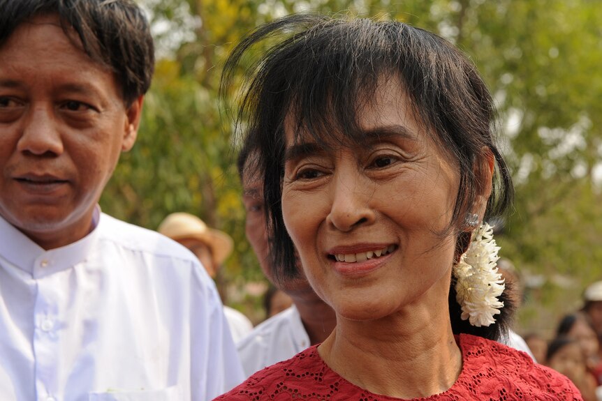 Burmese opposition leader Aung San Suu Kyi smiles as she leaves a polling station.