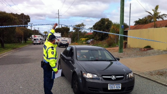 WA police officer holds up crime tape at the scene of a fatal stabbing in Noranda 2 august 2010