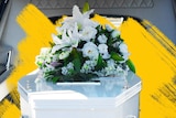 White coffin with white bouquet in a hearse.