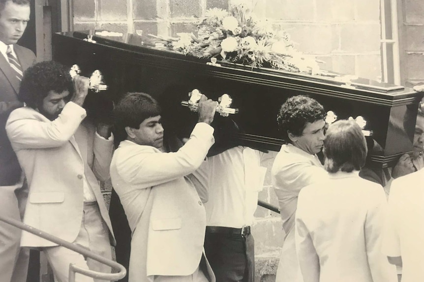 Marks dad and uncles carrying his coffin to the hearse.