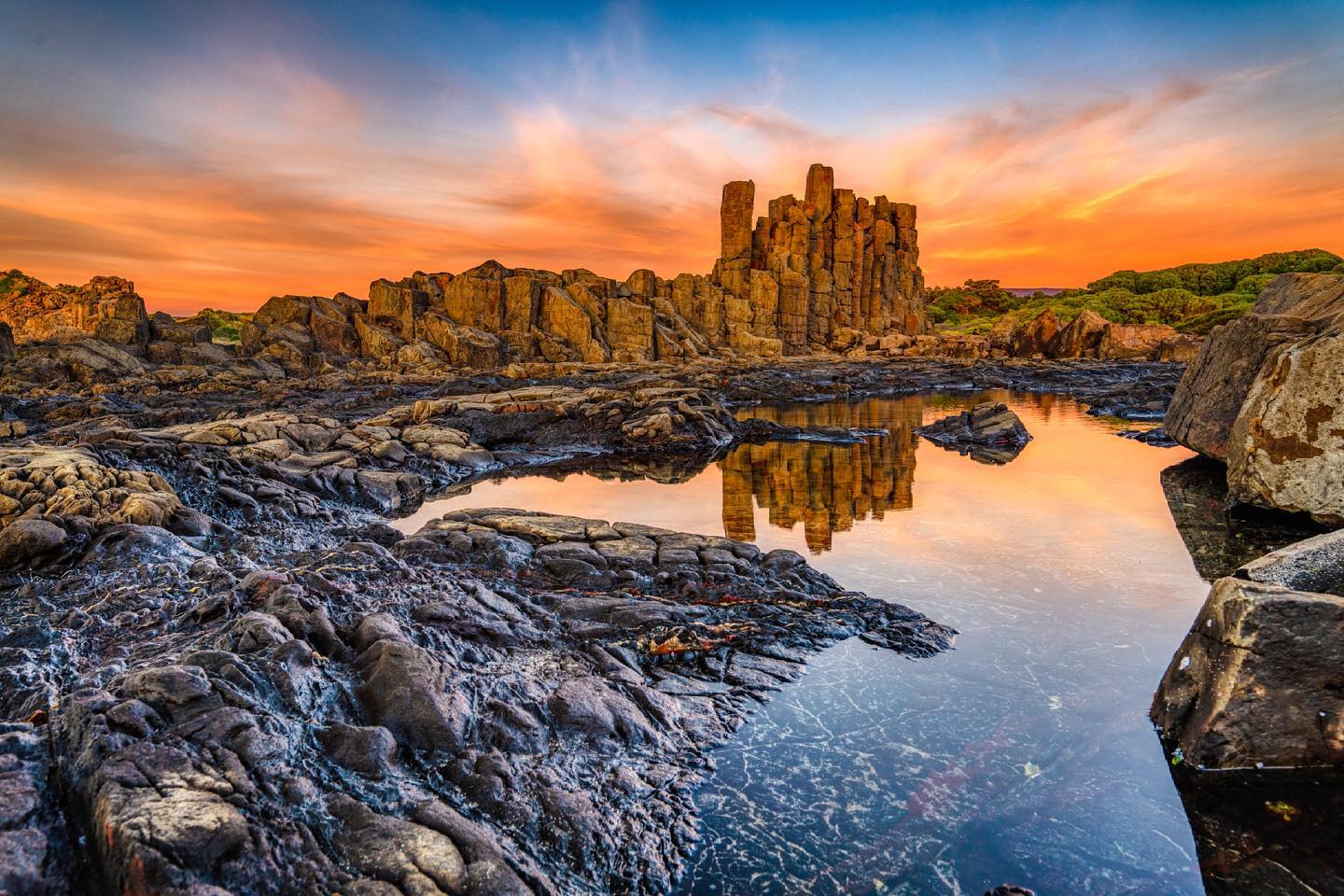 An atmospheric photo of a quarry with hexagonal columns of rock.
