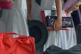 Generic TV still of school kids (no faces shown) carrying books with bags in foreground.