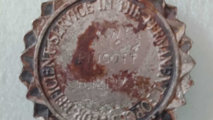 A military service medal with a number and the name "Pincott" inscribed